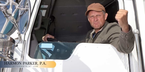 Upset truck driver shaking his fist out the window